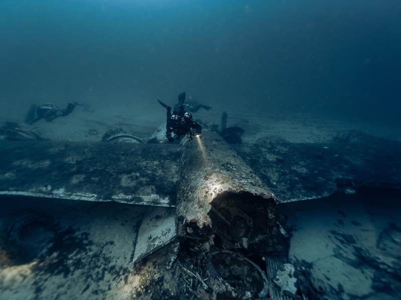 B-24 Liberator tail section with diver at 58m. Photo: Jon Borg