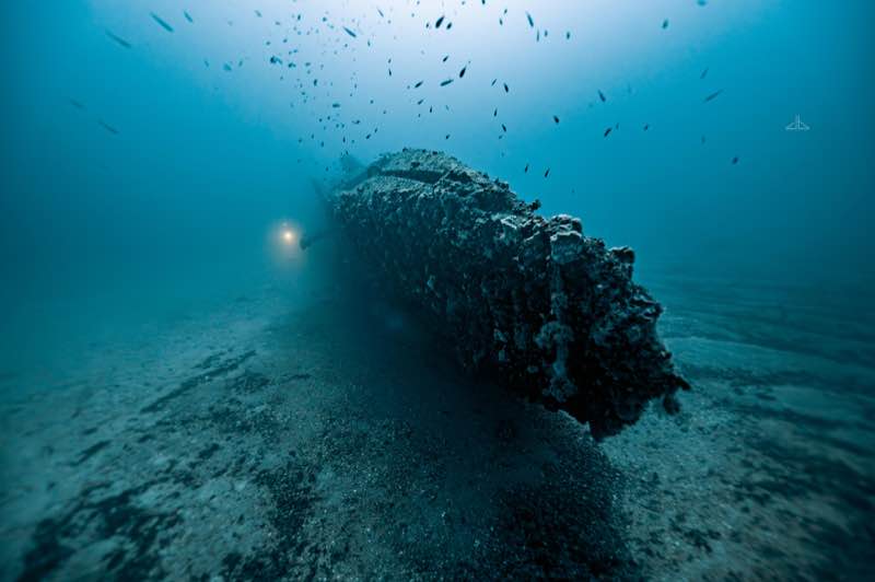HMS Stubborn bow and torpedo tube area at 48m with diver torch. Photo: Jon Borg